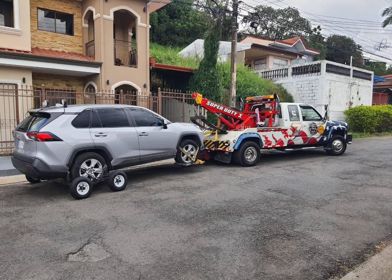 Unidad de arrastre Super Duty de Grúas Zamora Moya, rotulada con la bandera de Estados Unidos, remolcando una camioneta en Costa Rica