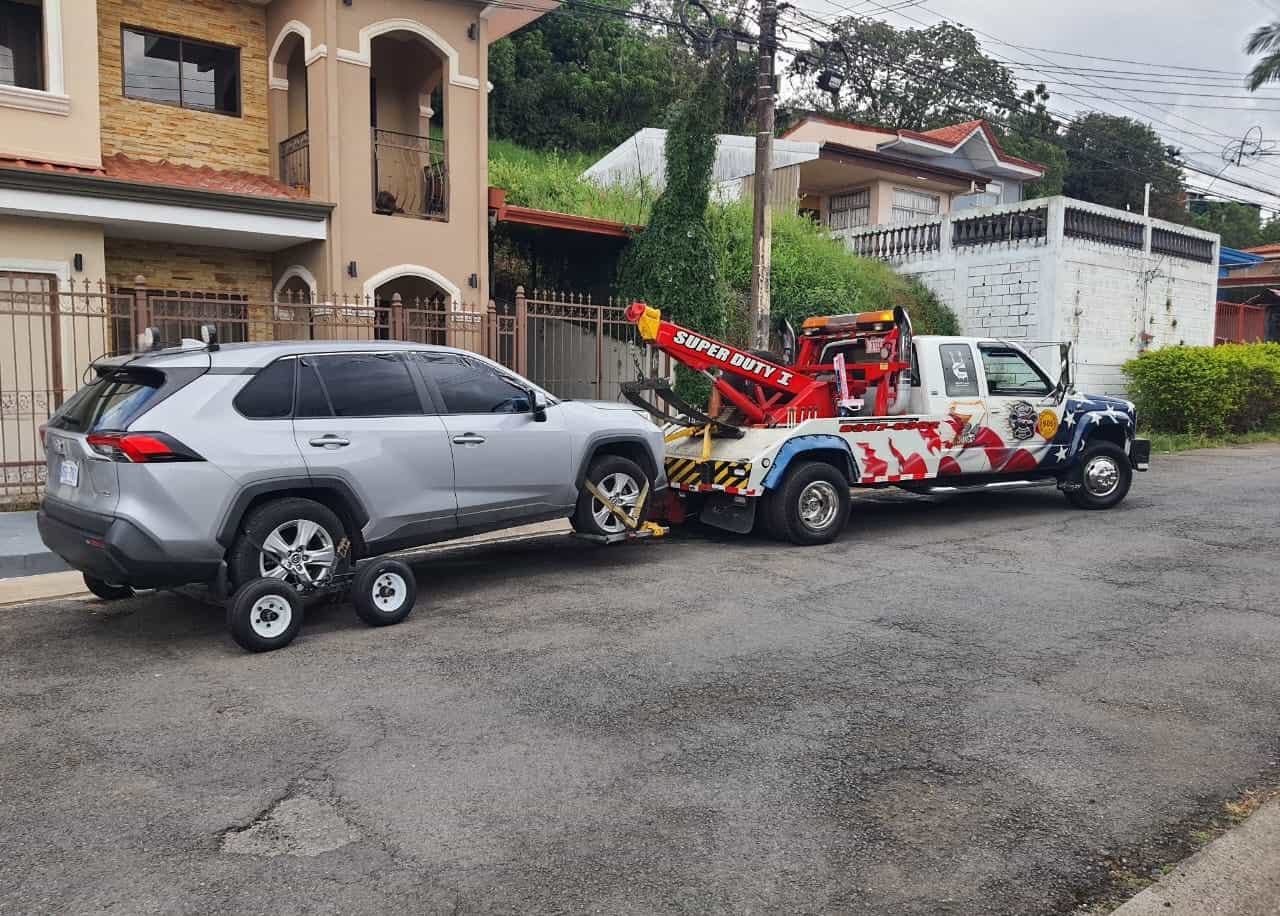 Speed dollies bajo las llantas traseras de un vehículo remolcado por Grúas Zamora Moya, el método que permite mover un carro eléctrico sin que las ruedas giren